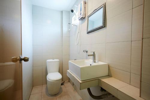 a bathroom with a white toilet and a sink at Mawar Villa, Batu Hitam in Kuantan