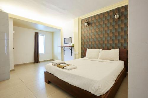 a bedroom with a large bed with white sheets at Mawar Villa, Batu Hitam in Kuantan