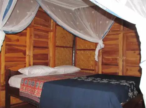 a bedroom with a bed and a canopy at GUEST HOUSE in Ndangu