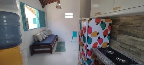 uma cozinha com um fogão e um frigorífico com uma janela em Chalés Jardins dos Cajueiros em Tamandaré