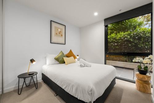 Un dormitorio con una cama grande y una ventana en StayCentral - Hawthorn East - Study, 2 Car spaces en Melbourne