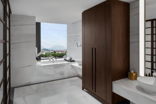 a bathroom with two sinks and a window at Crowne Plaza Vinh Yen City Centre by IHG in Yen