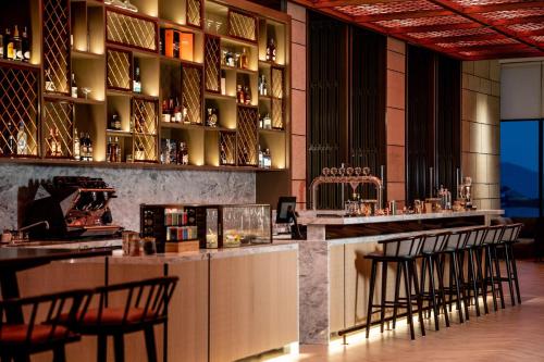 a bar in a restaurant with stools at a counter at Crowne Plaza Vinh Yen City Centre by IHG in Yen