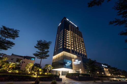 a tall building with lights on it at night at Crowne Plaza Vinh Yen City Centre by IHG in Yen