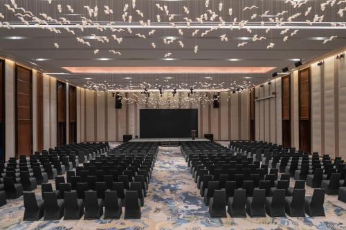 a large room with chairs and a projection screen at Crowne Plaza Vinh Yen City Centre by IHG in Yen
