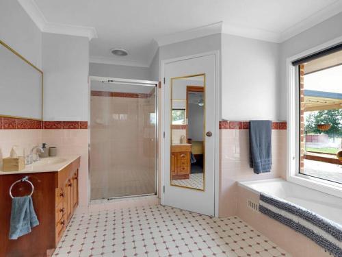 uma casa de banho com um chuveiro, uma banheira e um lavatório. em Lilly Pilly Lodge em Wallalong