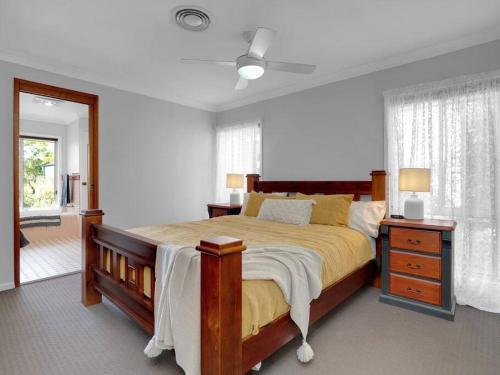 um quarto com uma cama grande e uma janela em Lilly Pilly Lodge em Wallalong
