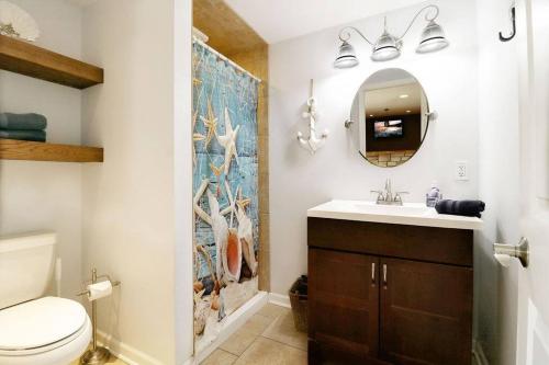 un bagno con lavandino, WC e specchio di Chain O Lakes Nautical 4Bed 3Bath Waterfront with Bonus Room, Large Deck and Hot Tub a Fox Lake