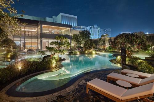釜山的住宿－釜山樂天酒店，一座游泳池,在晚上在建筑物前