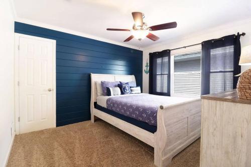 una camera da letto con pareti blu e un letto con ventilatore a soffitto di Chain O Lakes Nautical 4Bed 3Bath Waterfront with Bonus Room, Large Deck and Hot Tub a Fox Lake