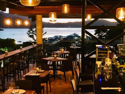 a restaurant with tables and chairs and a view of the ocean at Hotel puesta del sol in Valle de Bravo