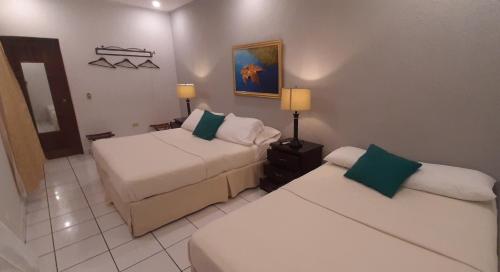 a hotel room with two beds and a couch at Hotel San Jose, Matagalpa. in Matagalpa