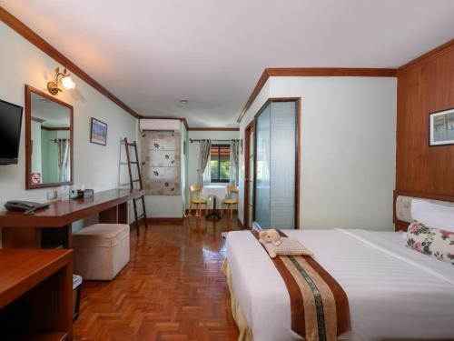 a bedroom with a bed and a desk and a mirror at Estia Chiangmai in Chiang Mai