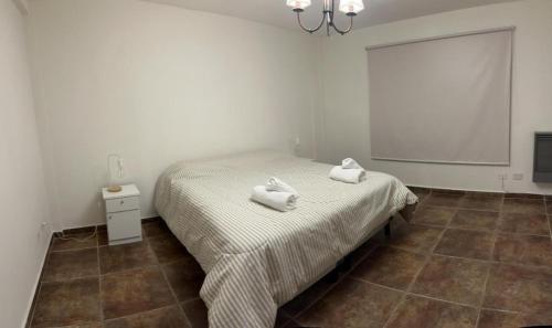 1 dormitorio con 1 cama con toallas en Dpto amplio con vista a la bahía en Ushuaia