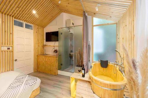 ein großes Bad mit einer Holzbadewanne und einer Dusche in der Unterkunft HomestayCHAT*TropicalHome1*OldQuarter*Hanoi in Hanoi