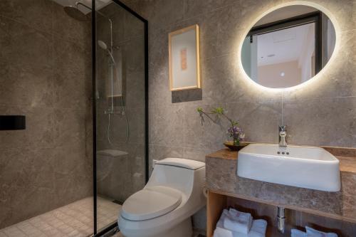 a bathroom with a toilet and a sink and a mirror at Beijing Heyuan Courtyard Hotel (Forbidden City) in Beijing