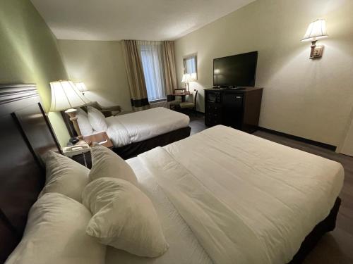 a hotel room with two beds and a flat screen tv at Comfort Inn Pinehurst - Southern Pines in Pinehurst