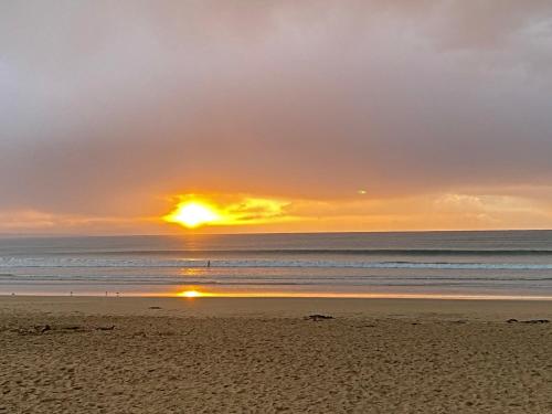 a sunset on a beach with the ocean at Lorne Surf Apartments in Lorne