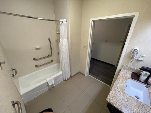 a bathroom with a bath tub and a sink at Comfort Inn Pinehurst - Southern Pines in Pinehurst