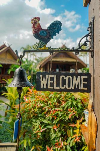 a welcome sign with a rooster and a bell at Pai Homey in Pai