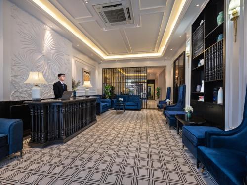 a man standing at a reception desk in a hotel lobby at The Flower Boutique Hotel & Travel in Hanoi