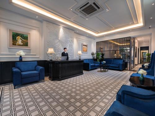 a man sitting at a desk in a hotel lobby at The Flower Boutique Hotel & Travel in Hanoi