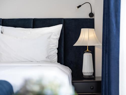 a bed with a black headboard and a lamp on a table at The Flower Boutique Hotel & Travel in Hanoi