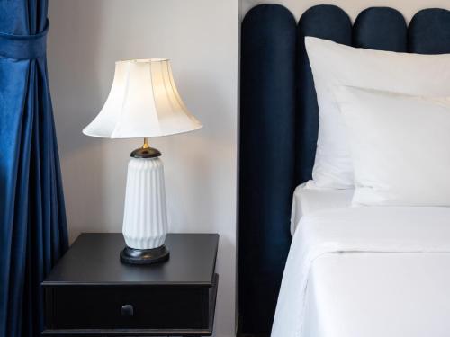 a lamp on a night stand next to a bed at The Flower Boutique Hotel & Travel in Hanoi
