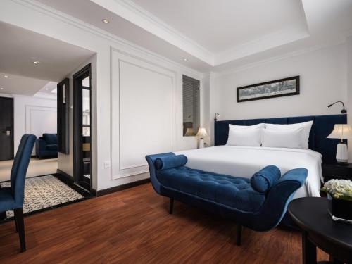 a bedroom with a large bed and a blue couch at The Flower Boutique Hotel & Travel in Hanoi