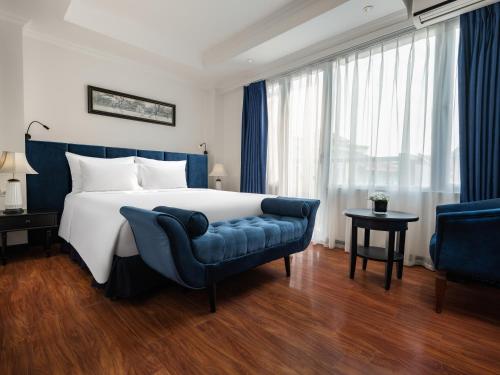 a bedroom with a large bed and a blue couch at The Flower Boutique Hotel & Travel in Hanoi