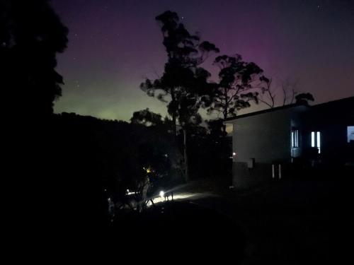 a night time picture of a house with a green sky at Hill Top Retreat in Nubeena