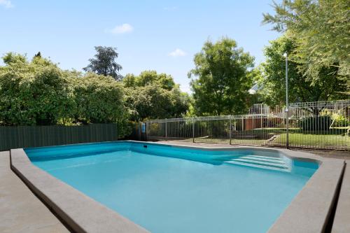 a swimming pool in a yard with a fence at "Uralla" Lovely house with pool in Bathurst