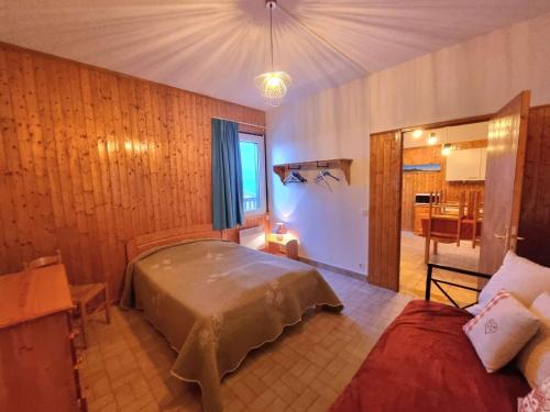 une chambre avec un lit et un canapé dans une pièce dans l'établissement Appartement cosy à Chaillol 1600, 6-8 pers, terrasse sud, WiFi, parking proche - FR-1-393-31, à Saint-Michel-de-Chaillol