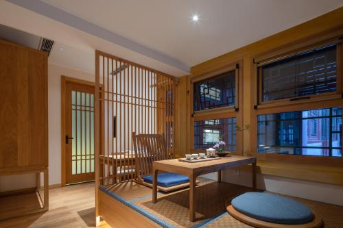 a room with a table and chairs and windows at Beijing Heyuan Courtyard Hotel (Forbidden City) in Beijing