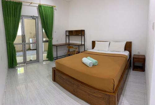 ein Schlafzimmer mit einem großen Bett mit grünen Vorhängen in der Unterkunft The Cheap & Cozy Canggu in Canggu