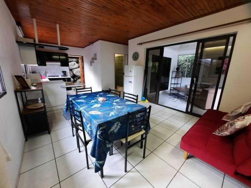 a kitchen and a dining room with a table and a couch at Vacation house in Tahiti in Punaauia