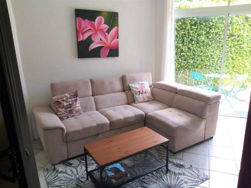 a living room with a couch and a table at Vacation house in Tahiti in Punaauia