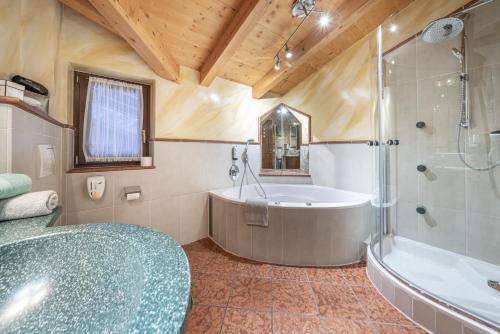 a bathroom with a tub and a shower and a sink at Heiners in Sölden