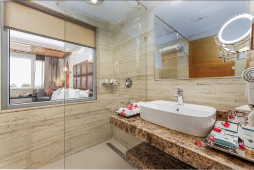 a bathroom with a sink and a mirror at Hotel Meerz in Srinagar