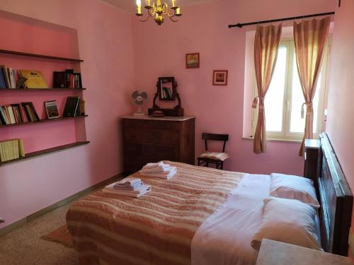 1 dormitorio con paredes rosas y 1 cama con sábanas blancas en Canalicchio Apartment Strategic for visiting Umbria, en Canalicchio