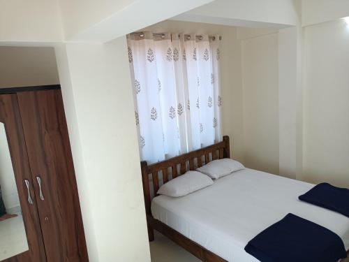 a small bedroom with a bed and a window at Sai Leela Guest House in Dabolim
