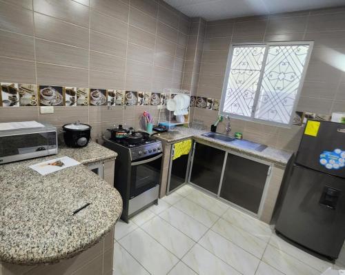 a kitchen with a stove and a refrigerator at Habitación privada en Salinas in Salinas