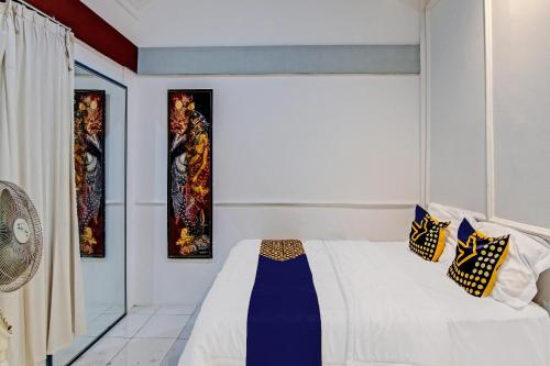 SPOT ON 92052 Aulya Homestay Syariah في Bangkinang: غرفة نوم بسرير وثلاث لوحات على الحائط