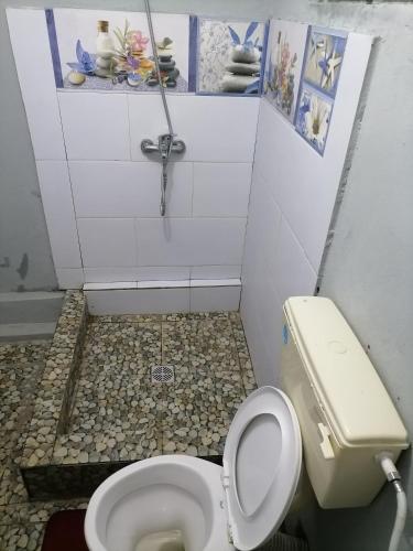ein kleines Bad mit WC und Fliesenboden in der Unterkunft Residence Brise marine in Rodrigues Island