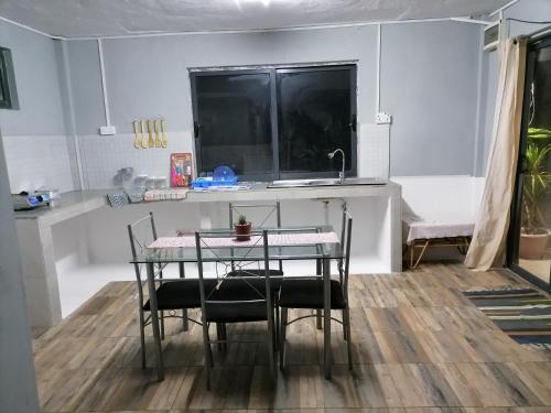 einen Tisch und Stühle in einer Küche mit Spüle in der Unterkunft Residence Brise marine in Rodrigues Island