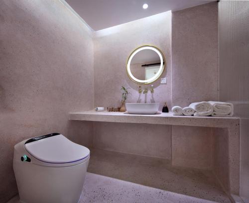 a bathroom with a sink and a toilet and a mirror at Sky Garden Inn in Guilin