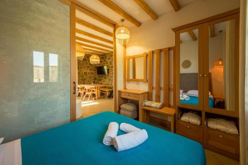 a bedroom with a blue bed with two towels at Aphrodite Stone Apartments in Moudhros