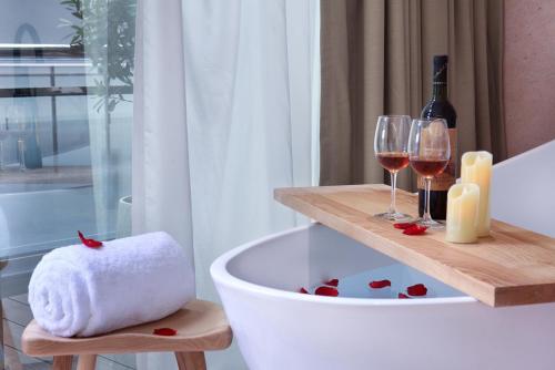 a bath tub with two glasses of wine and a towel at Sky Garden Inn in Guilin