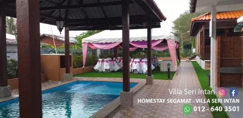 eine Hochzeitsparty unter einem Zelt neben einem Pool in der Unterkunft Homestay Segamat - Villa Seri Intan in Segamat