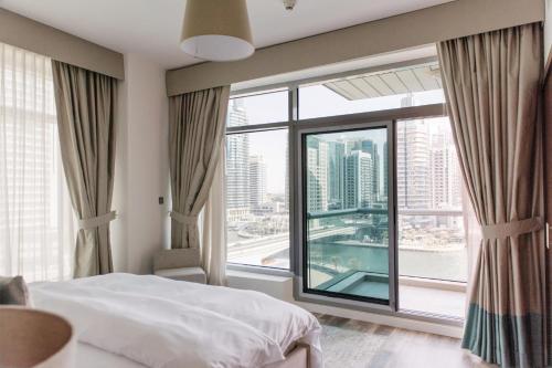 a bedroom with a bed and a large window at Boutique Living - Park Island in Dubai
